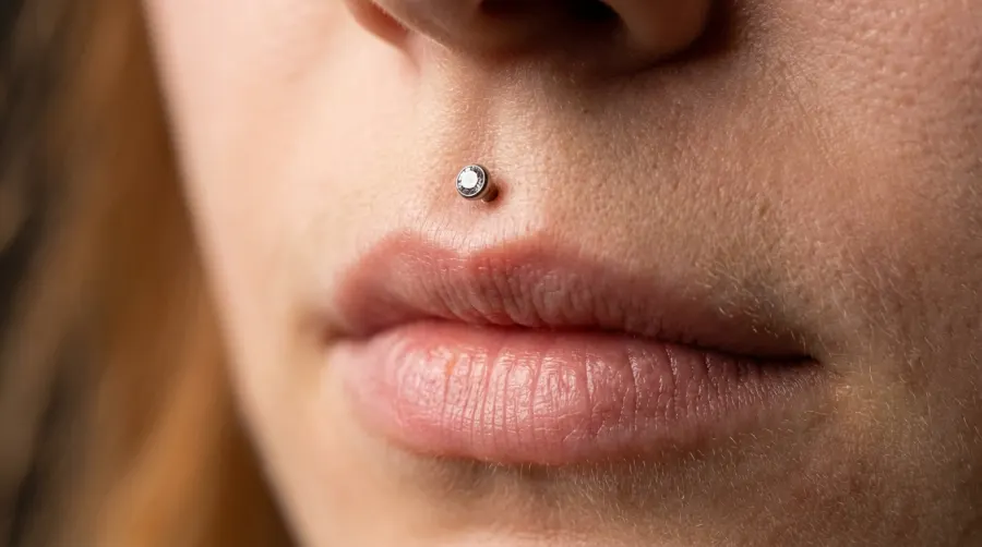 Zbliżenie na medusa piercing nad łukiem Kupidyna