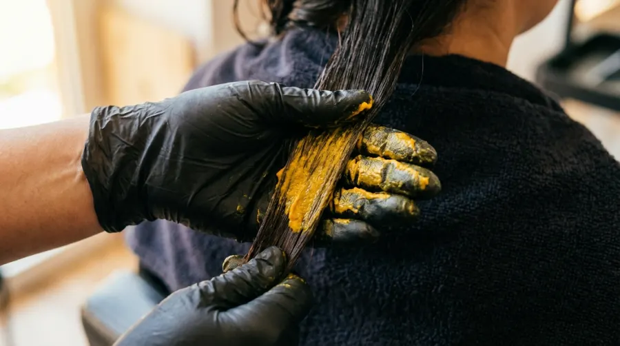 Bezpieczne nakładanie żółtej maski w ochronnych rękawiczkach lateksowych