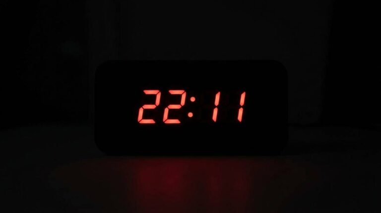 Wyświetlacz zegara cyfrowego pokazujący godzinę 22:11 na ciemnym, jednolitym tle