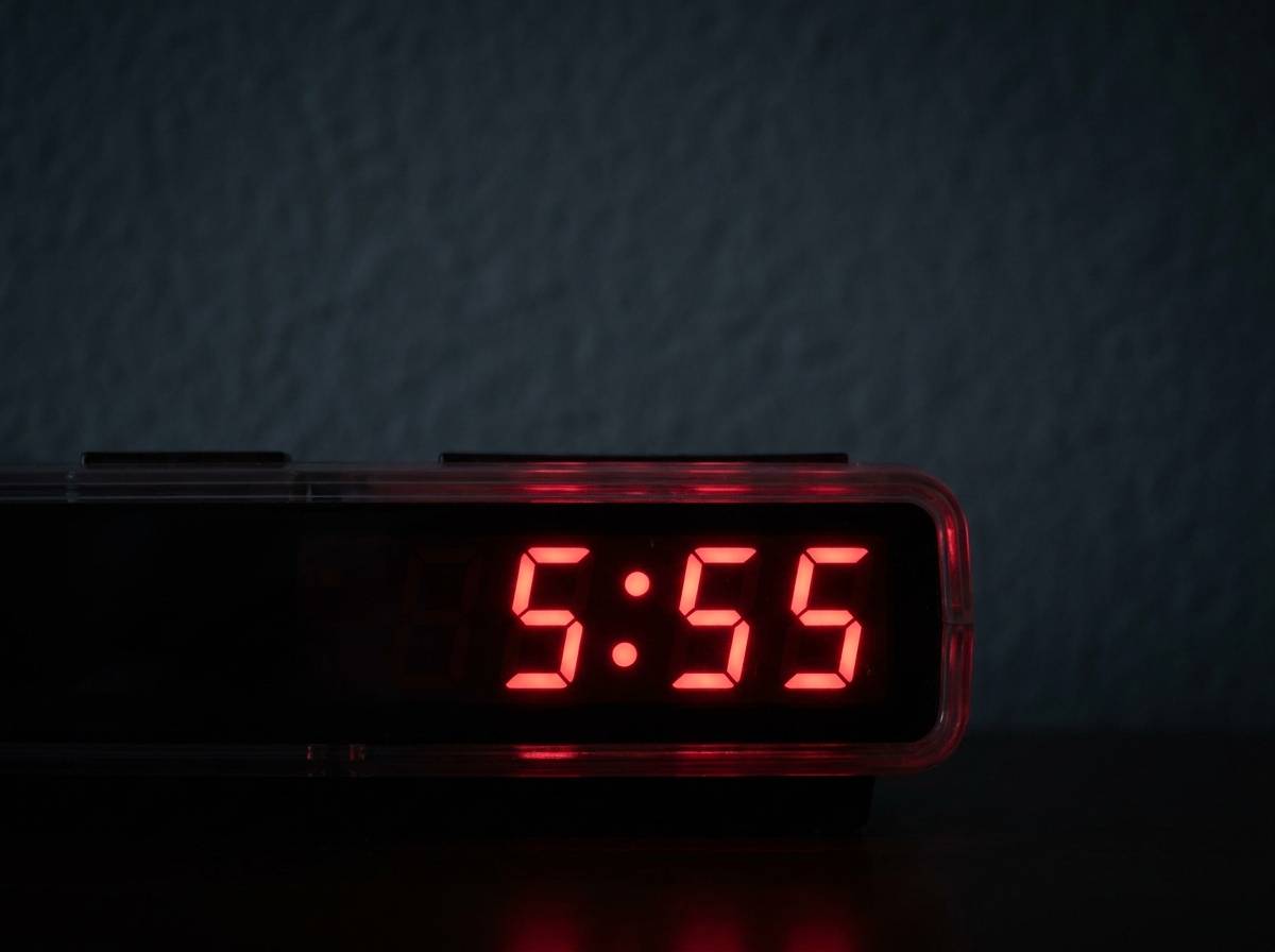 Cyfrowy wyświetlacz budzika wskazujący godzinę 5:55, najczęstsze miejsce spotkania z liczbą 555