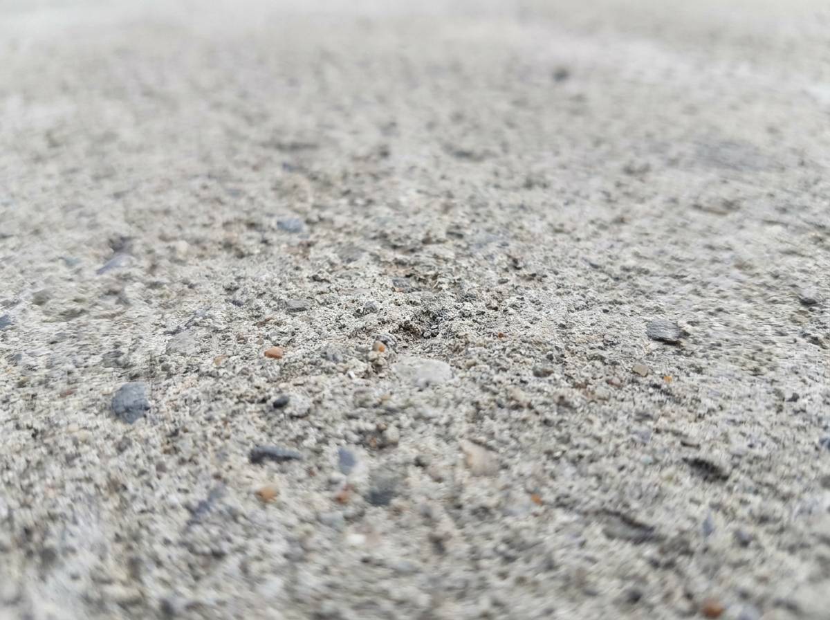 Surowa betonowa powierzchnia ilustrująca neutralność i minimalizm przypisywany kolorowi szaremu.