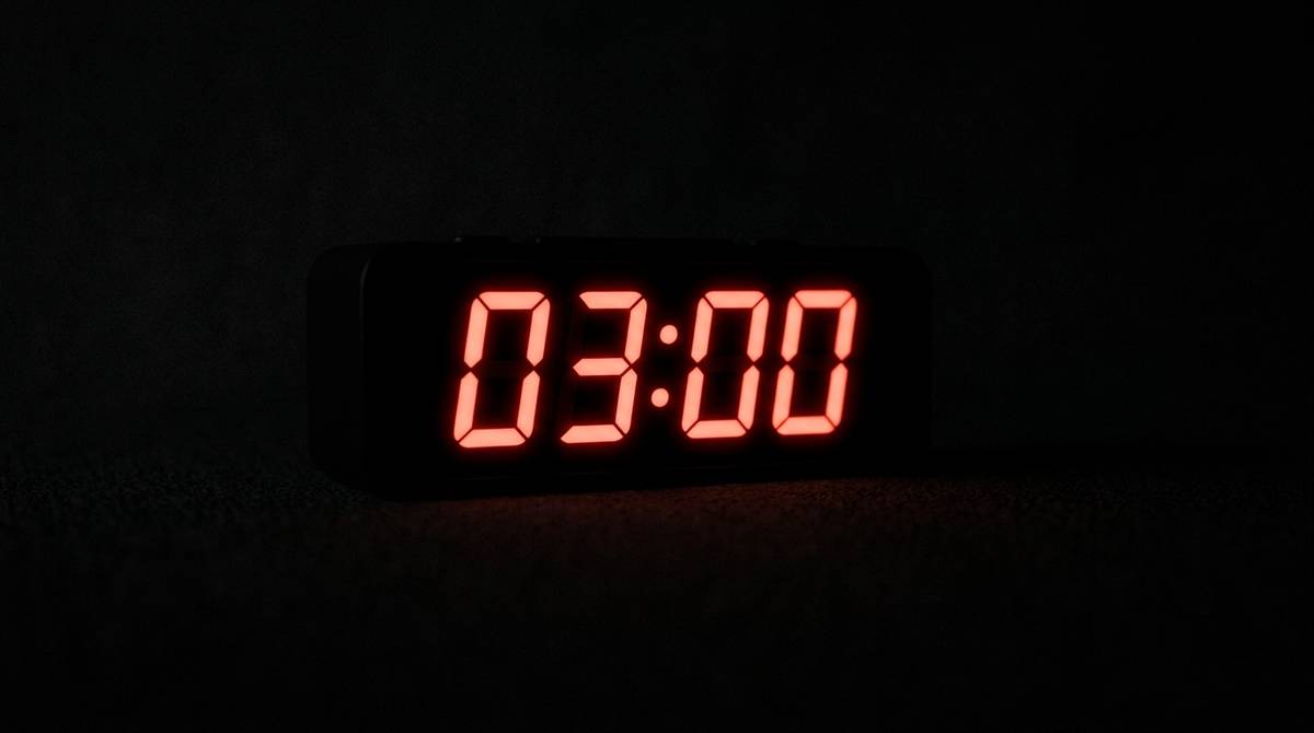 Wyświetlacz zegara pokazujący 03:00 w ciemnym pomieszczeniu nocą