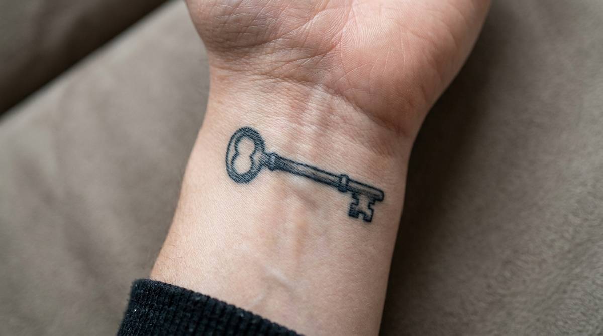 Klucz szkieletowy wytatuowany na nadgarstku, symbol uniwersalnego dostępu