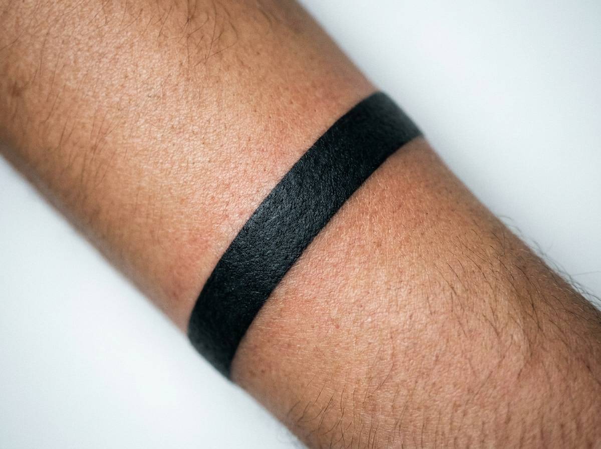 Tatuaż w paski z jednym czarnym paskiem otaczającym przedramię